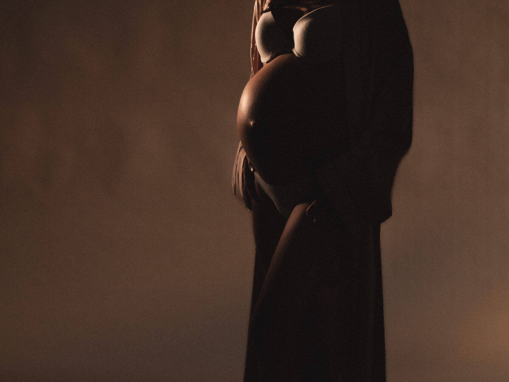 Pregnant woman silhouette smiles